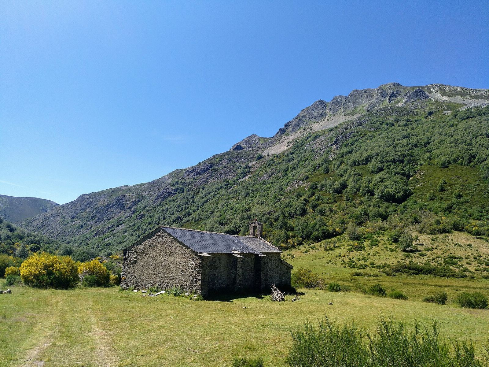 Ermita en los prados de Fasgar con la sierra detrás