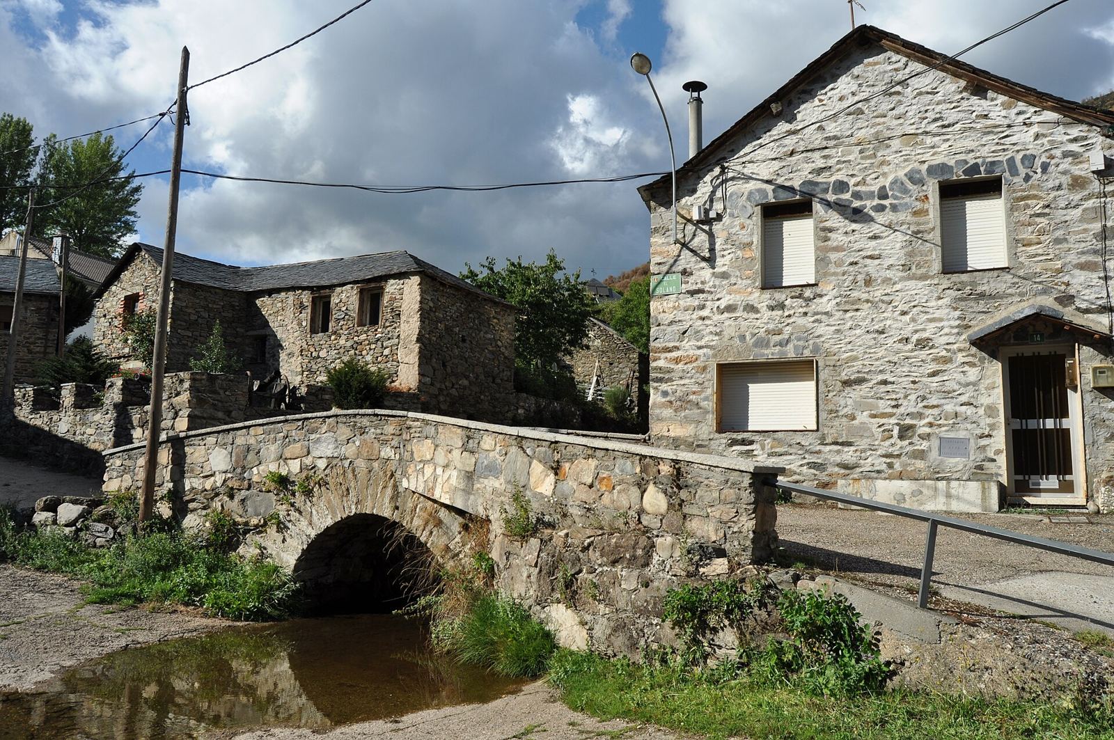 Puente de piedra y casas de pizarra en Fasgar