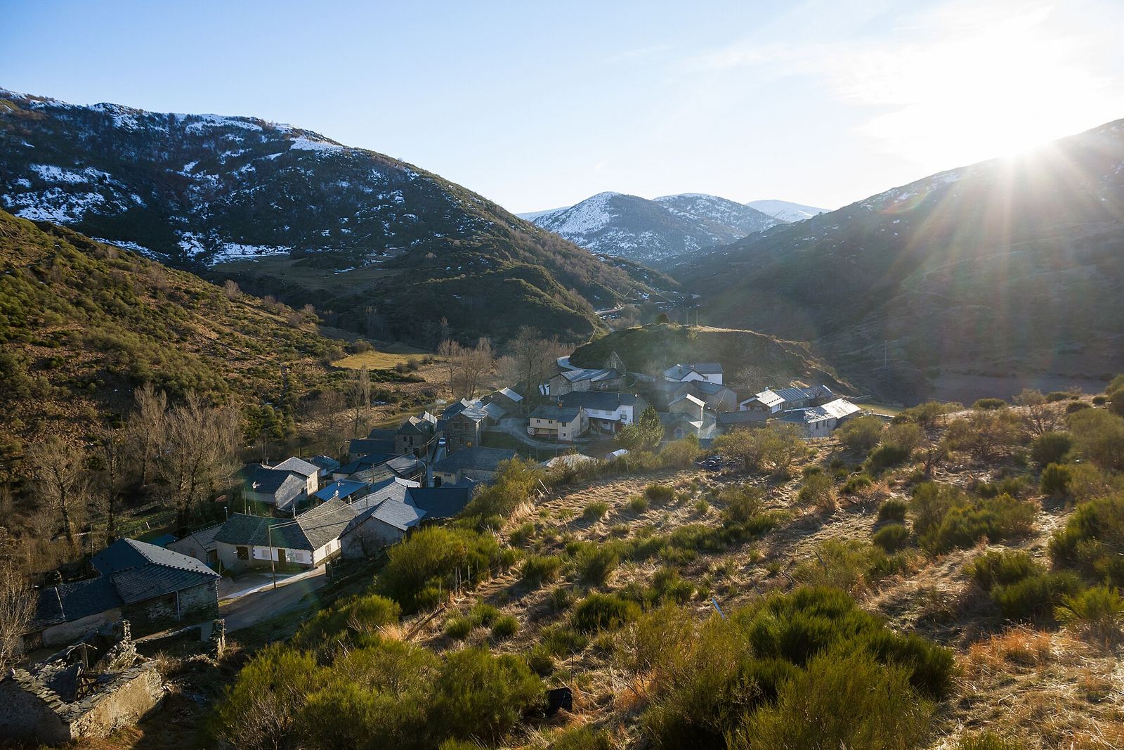 Pueblo de Omaña con las cumbres nevadas al atardecer